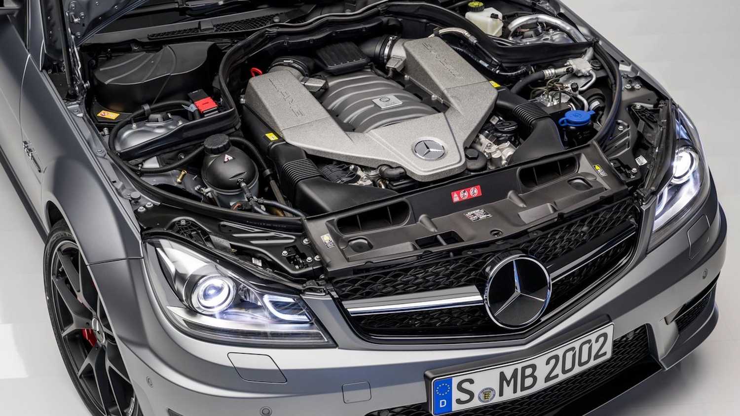 Vue rapprochée du moteur V8 d'une Mercedes-AMG C 63 (génération W204), mettant en valeur ses détails mécaniques et le logo AMG.