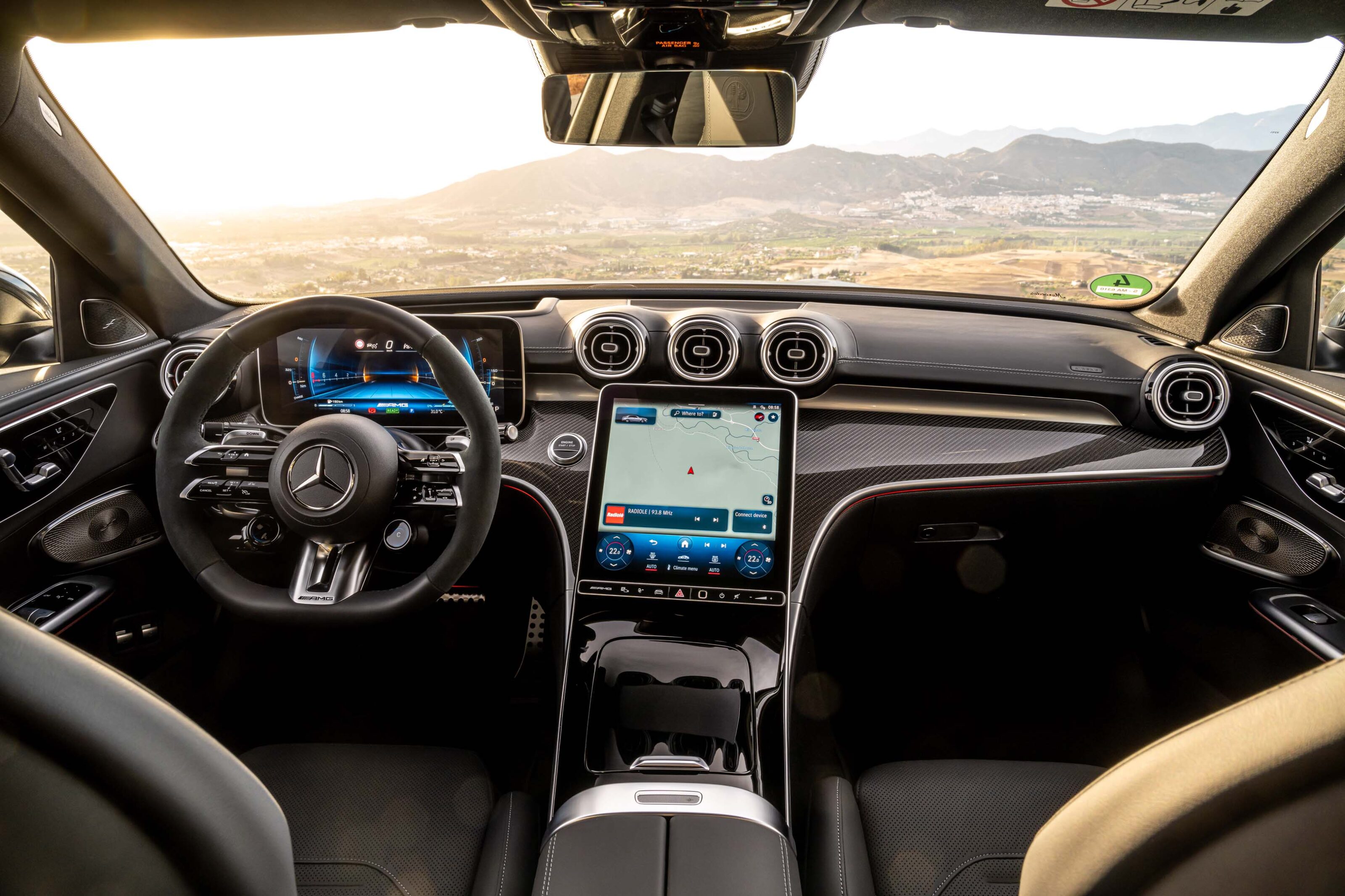 Intérieur moderne d'une Mercedes-AMG C 63 (génération W206) avec tableau de bord numérique et grand écran central.