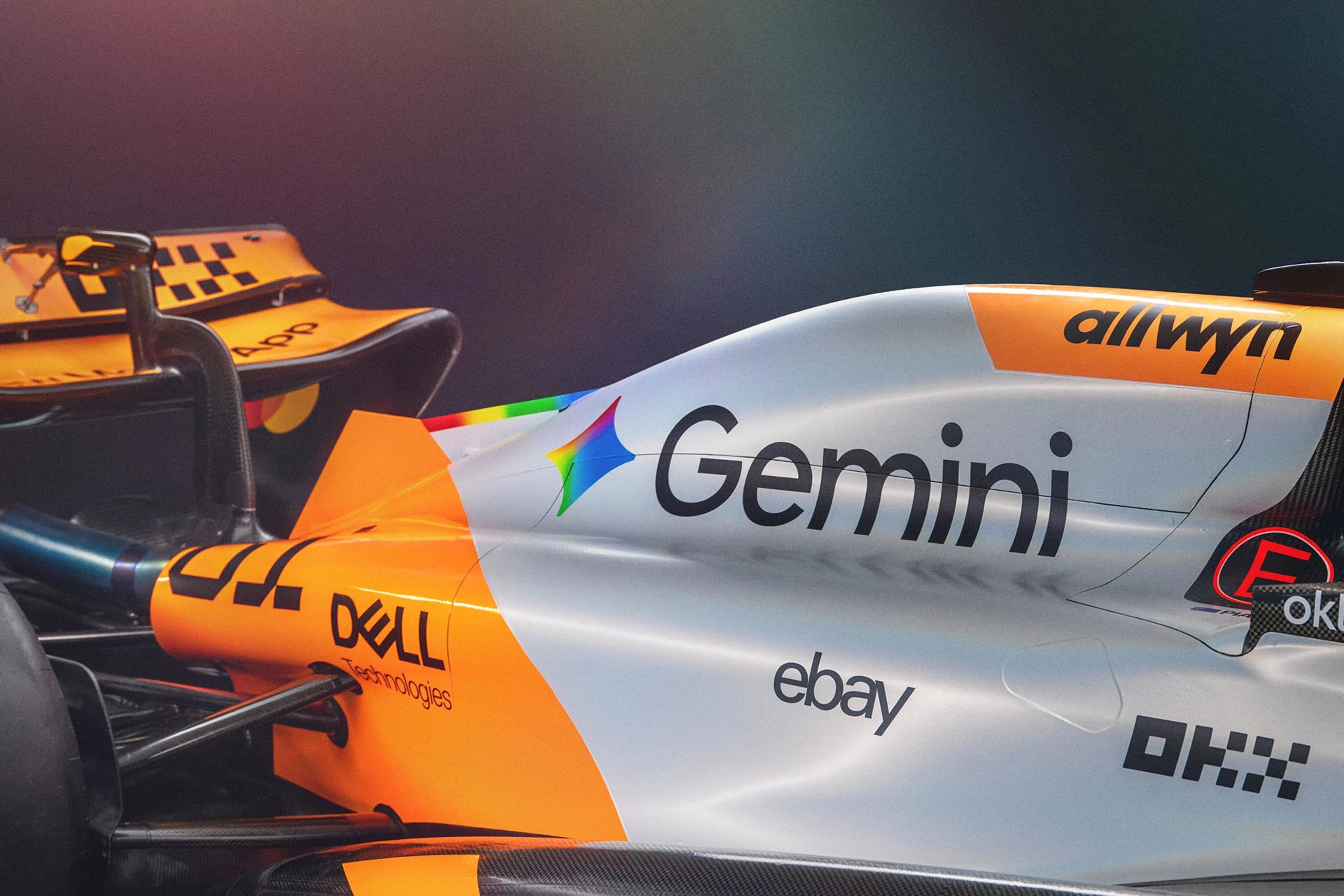 Une voiture de Formule 1 McLaren avec le logo Google Gemini, roulant sur une piste de course.