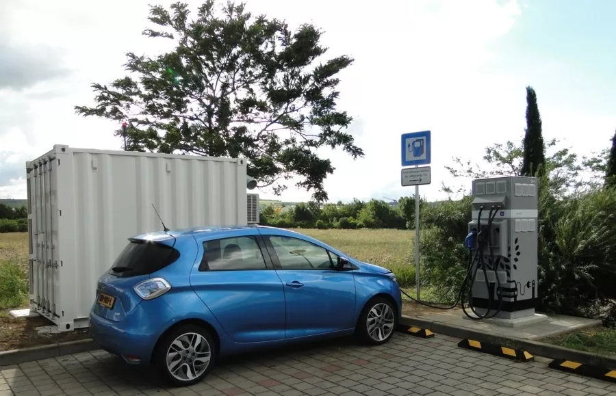 Une voiture électrique Renault, la Mégane E-Tech, en charge à une borne publique, symbolisant la transition électrique du groupe.