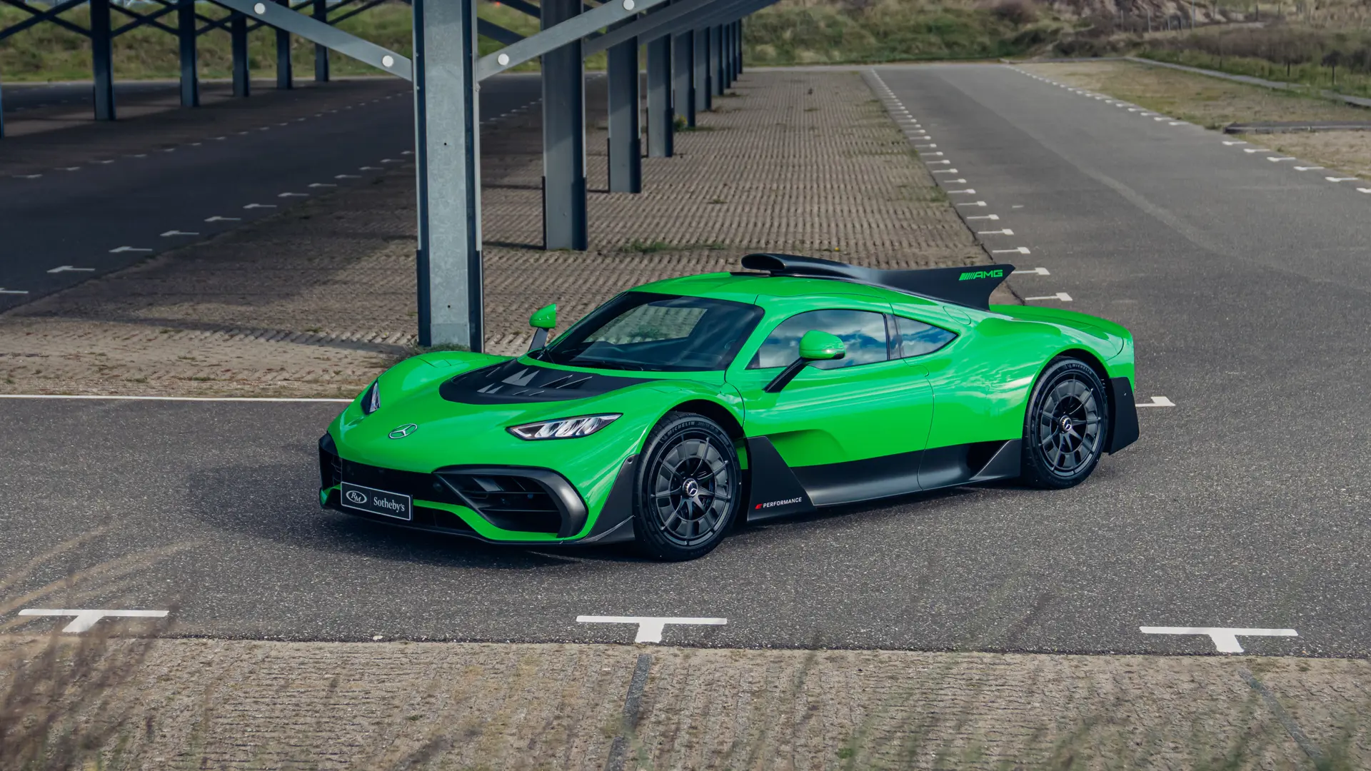 Une Mercedes-AMG One de couleur vert Reingrün, garée dans un showroom, avec des lumières douces.