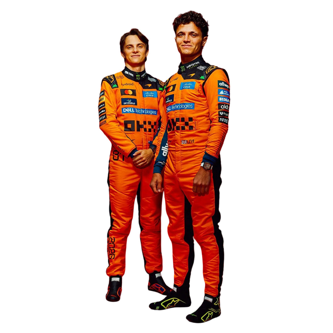 Lando Norris et Oscar Piastri en tenue de course McLaren, souriant dans un garage de Formule 1.