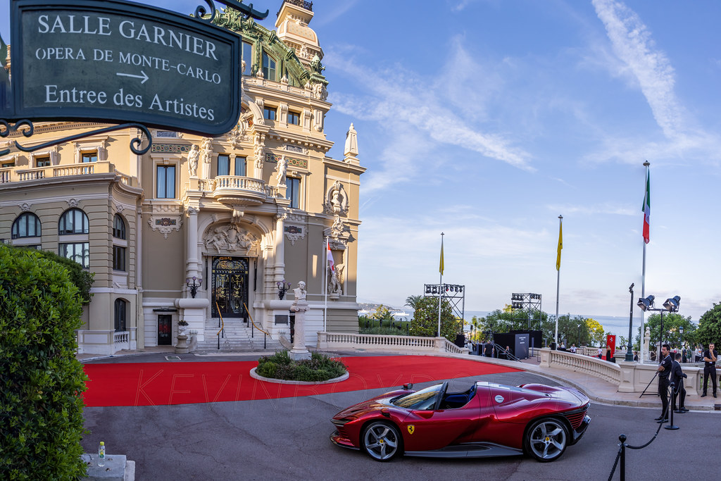 Une Ferrari Daytona SP3 rouge roulant dans les rues de Monte-Carlo.