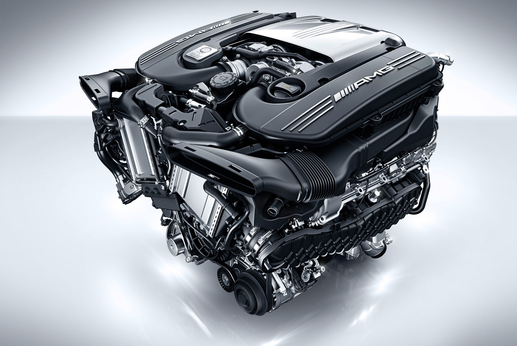 Gros plan détaillé d'un moteur V8 biturbo Mercedes-AMG, neuf et brillant, avec ses composants complexes.