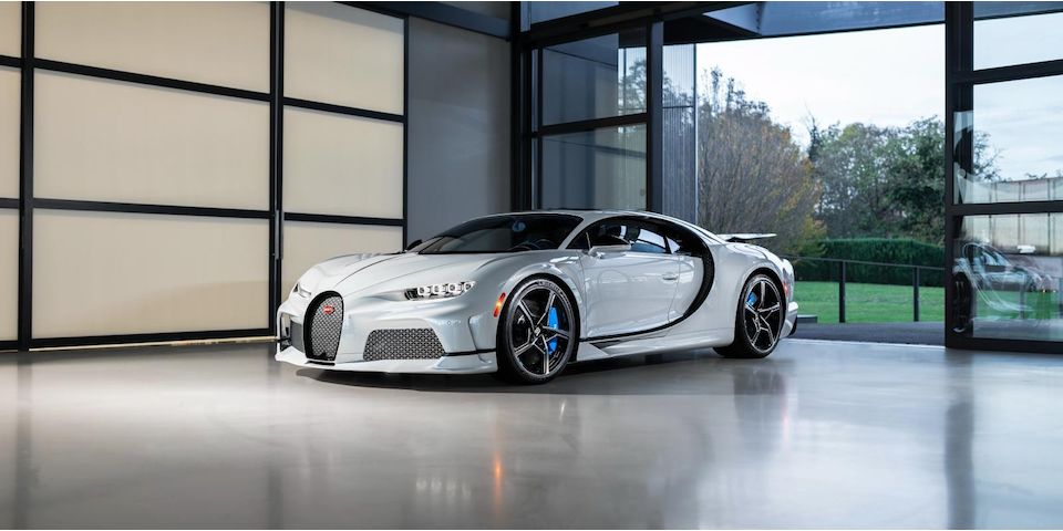 Une Bugatti Chiron Super Sport 300+ noire et orange, en mouvement dans les rues de Monaco.