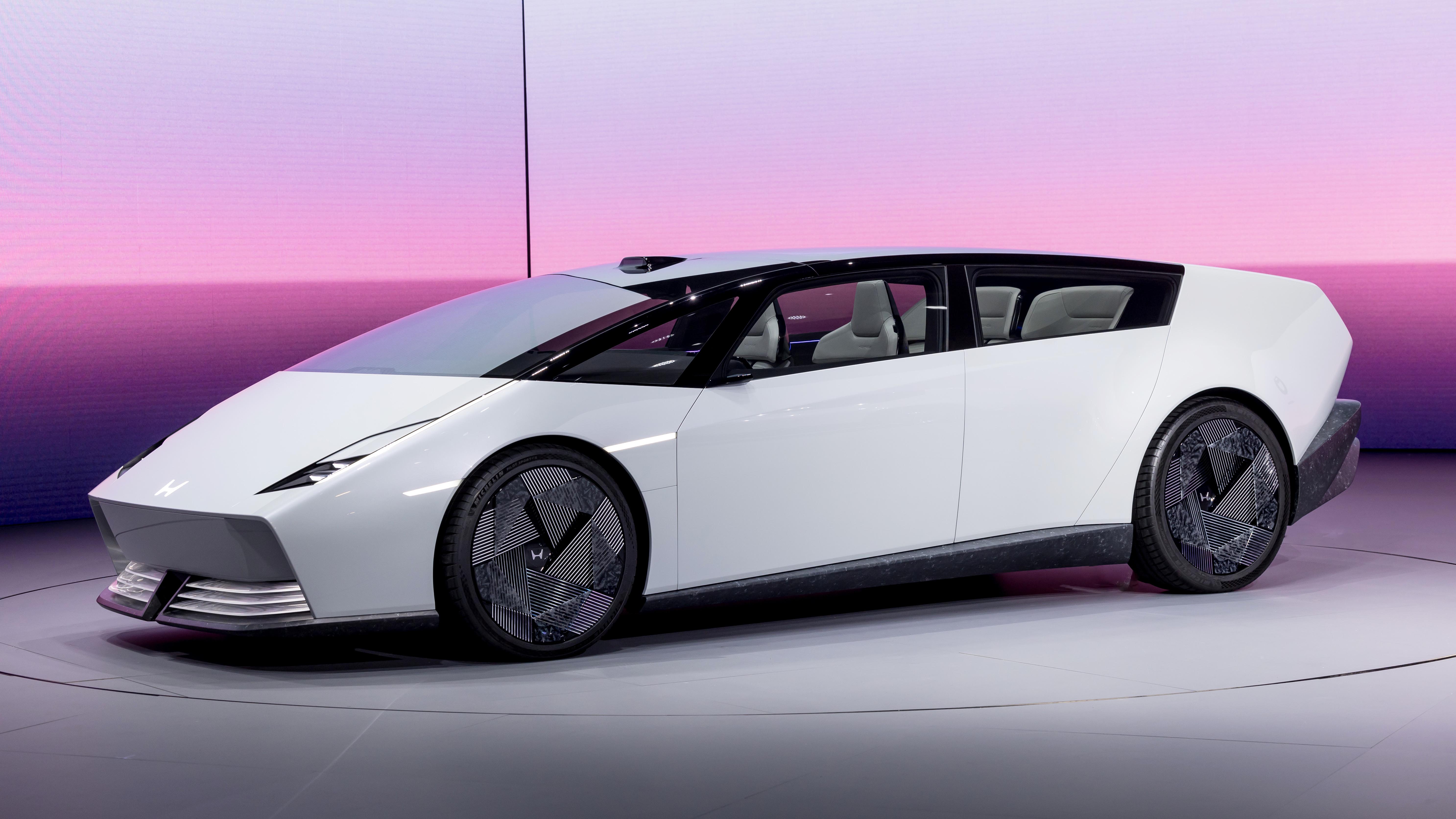Image d'un concept-car Honda 0 Saloon futuriste et élégant, de couleur claire, exposé dans un showroom moderne.