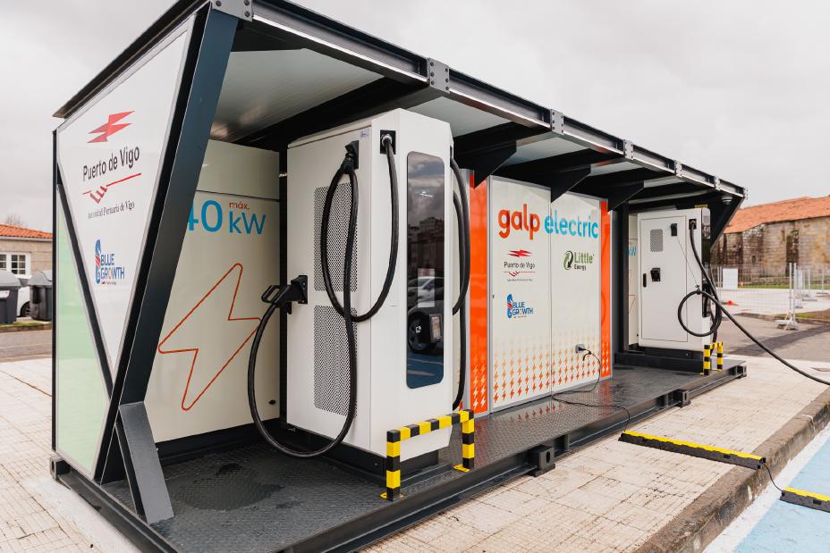 Une Nissan électrique branchée à une borne de recharge dans une rue européenne animée.