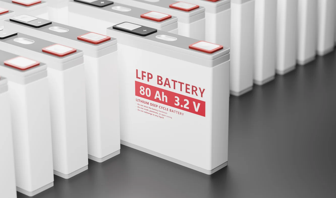 Gros plan sur un pack de batteries LFP moderne et compact pour véhicule électrique, avec des lignes de refroidissement visibles.