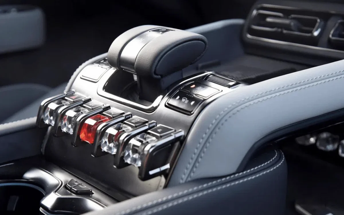 Vue de l'intérieur d'une voiture chinoise avec des boutons physiques bien visibles sur le tableau de bord, à côté d'un écran numérique.