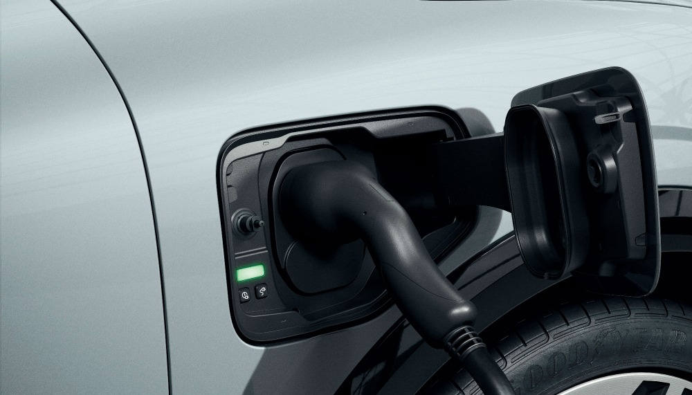 Un gros plan sur le port de charge d'une Renault Mégane E-Tech avec un câble de charge branché.