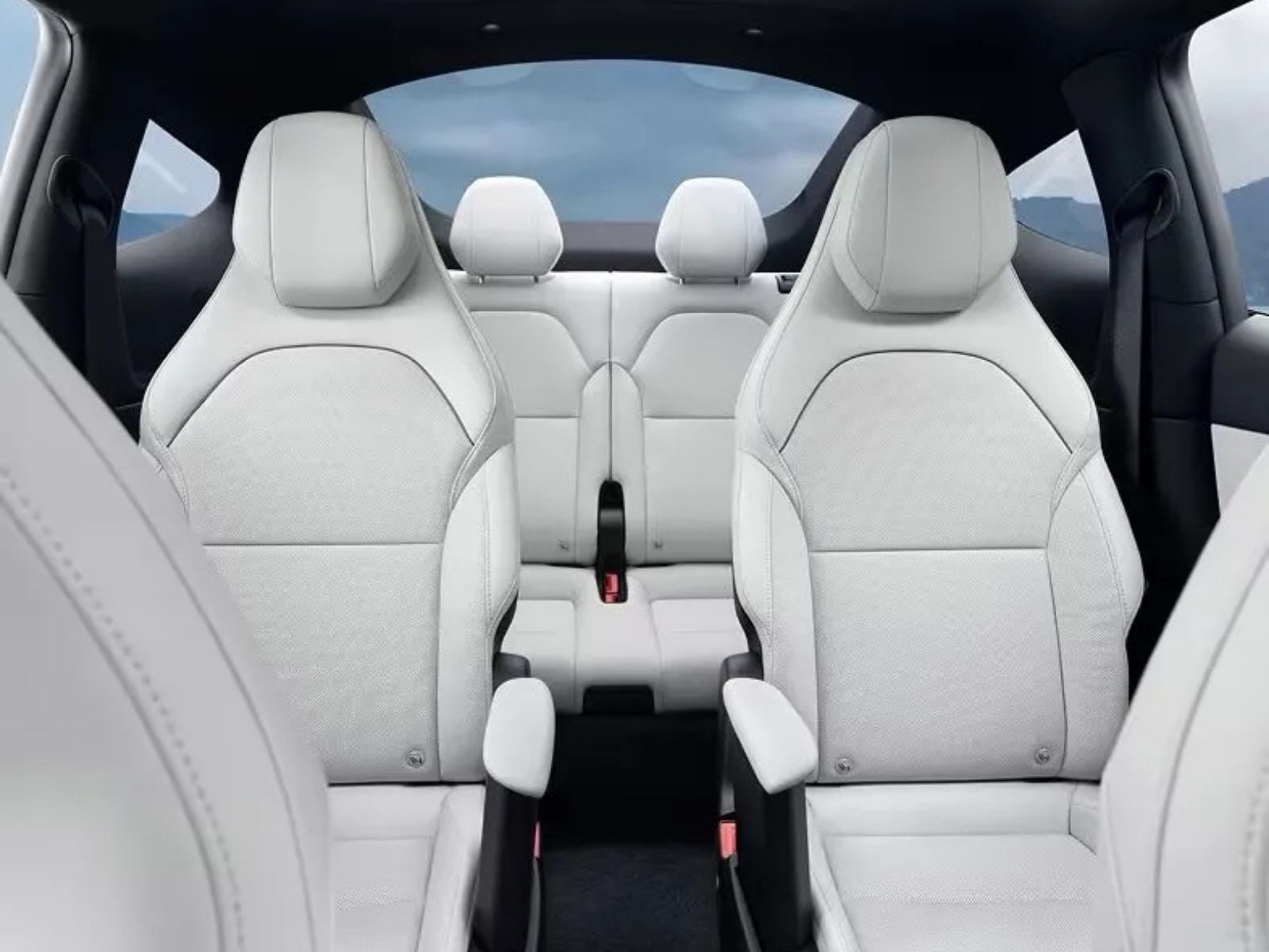 Vue intérieure d'une Tesla Model Y L, montrant la configuration à six places avec des sièges baquets au deuxième rang et des sièges rabattables au troisième rang, soulignant l'espace et le confort.
