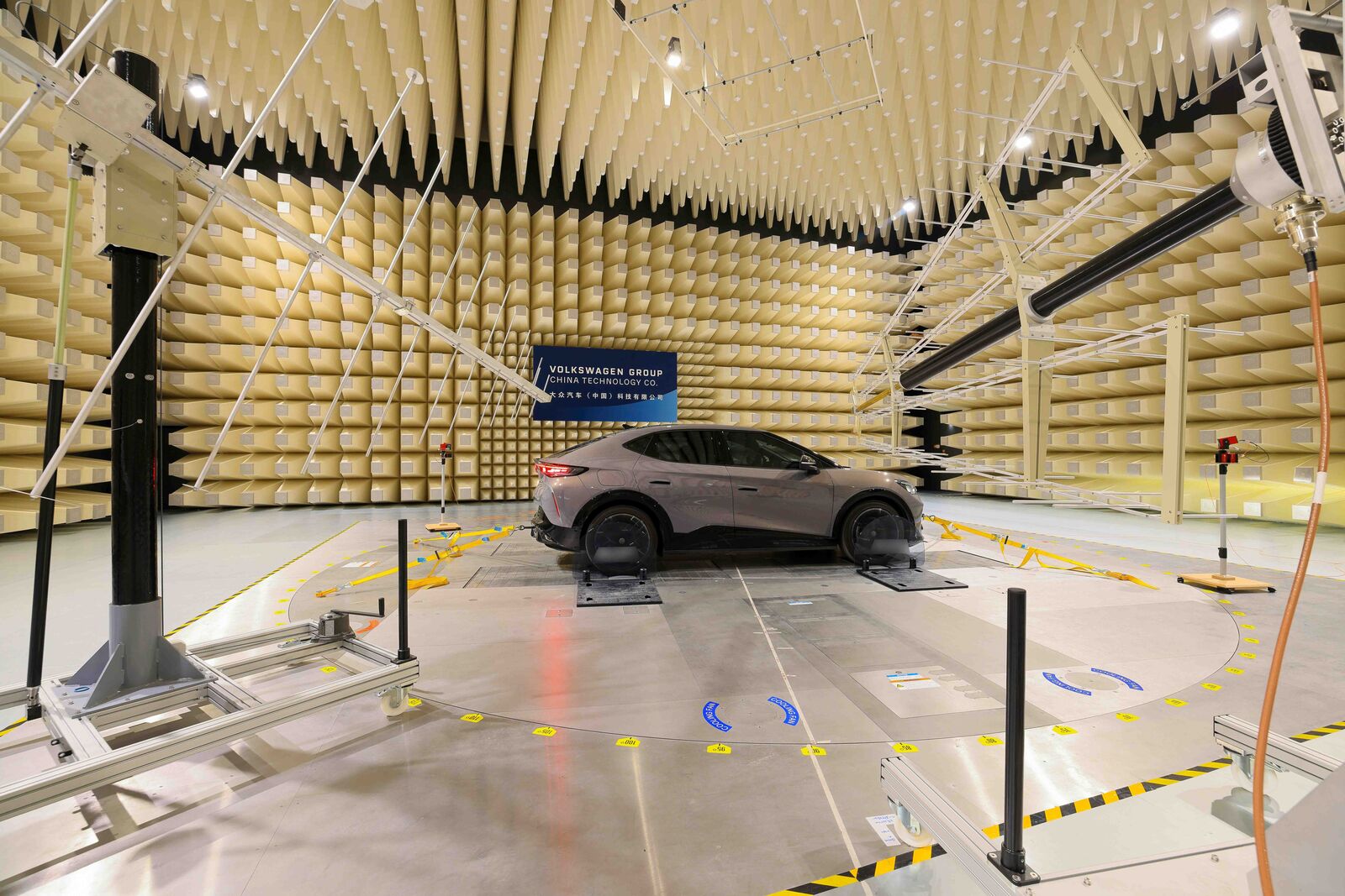 Un véhicule électrique Volkswagen en cours de test dans un environnement enneigé et glacé, avec des ingénieurs observant des données, illustrant le développement de plateformes logicielles avancées.