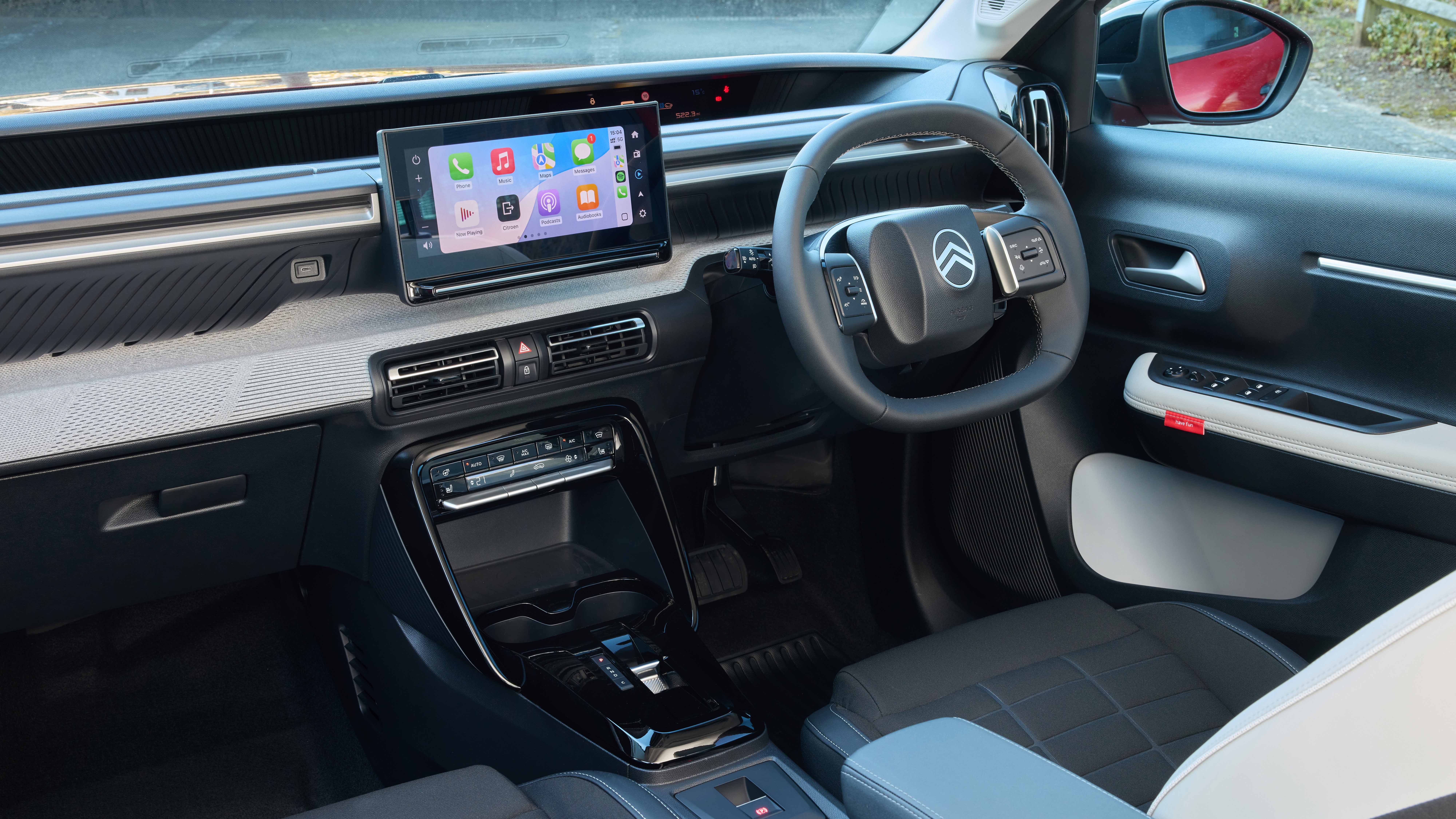 Tableau de bord intérieur d'une Citroën ë-C3, avec un grand écran tactile central et des sièges confortables.