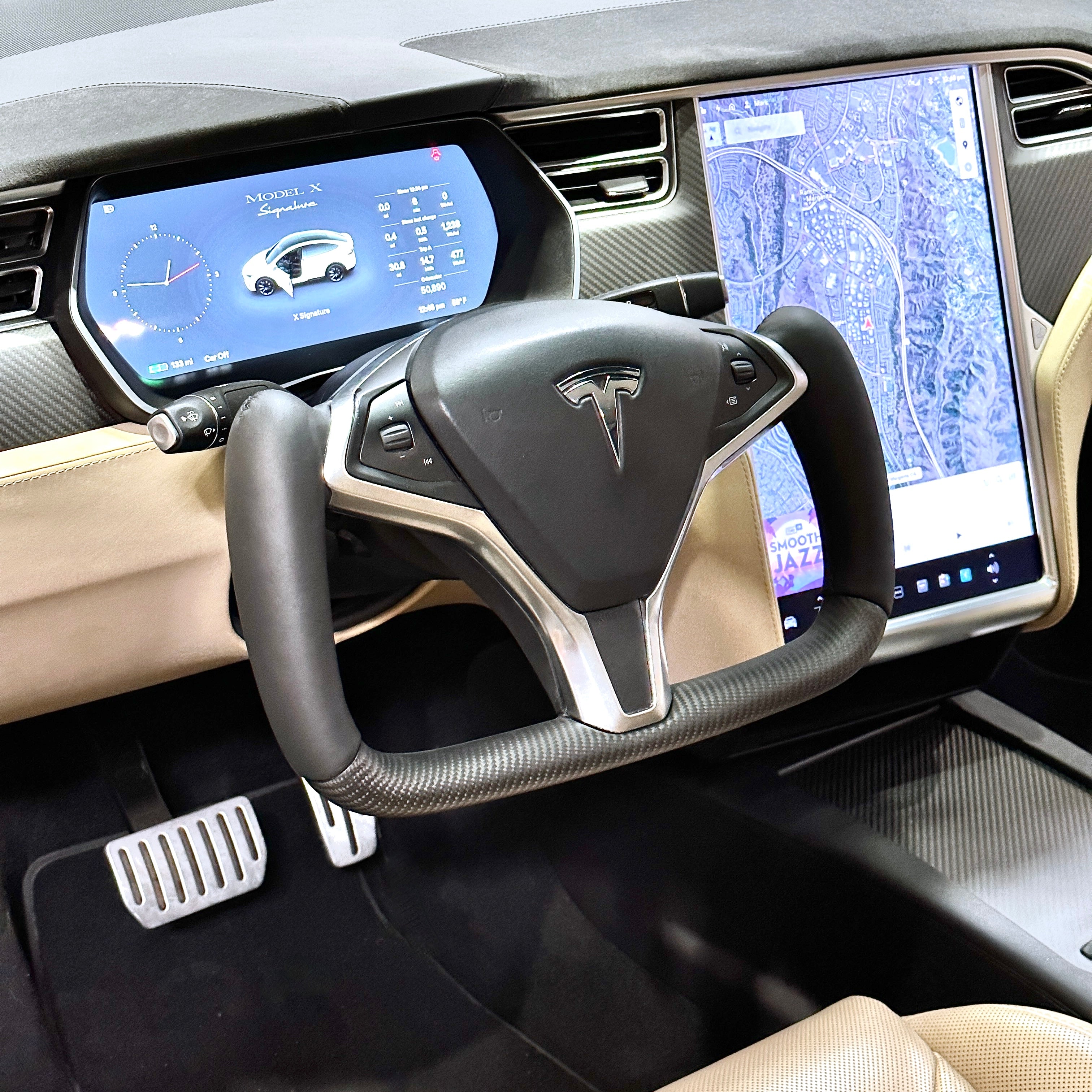 Vue rapprochée de l'intérieur d'une Tesla Model X, montrant le volant Yoke de forme non conventionnelle.