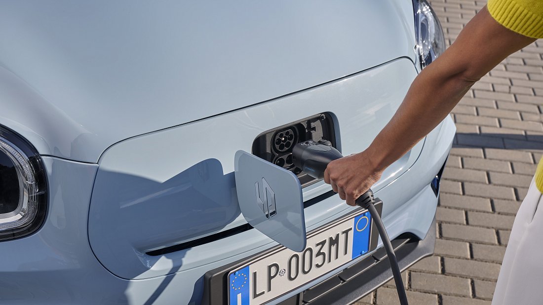 Une Leapmotor T03 blanche en charge sur une borne électrique en ville.