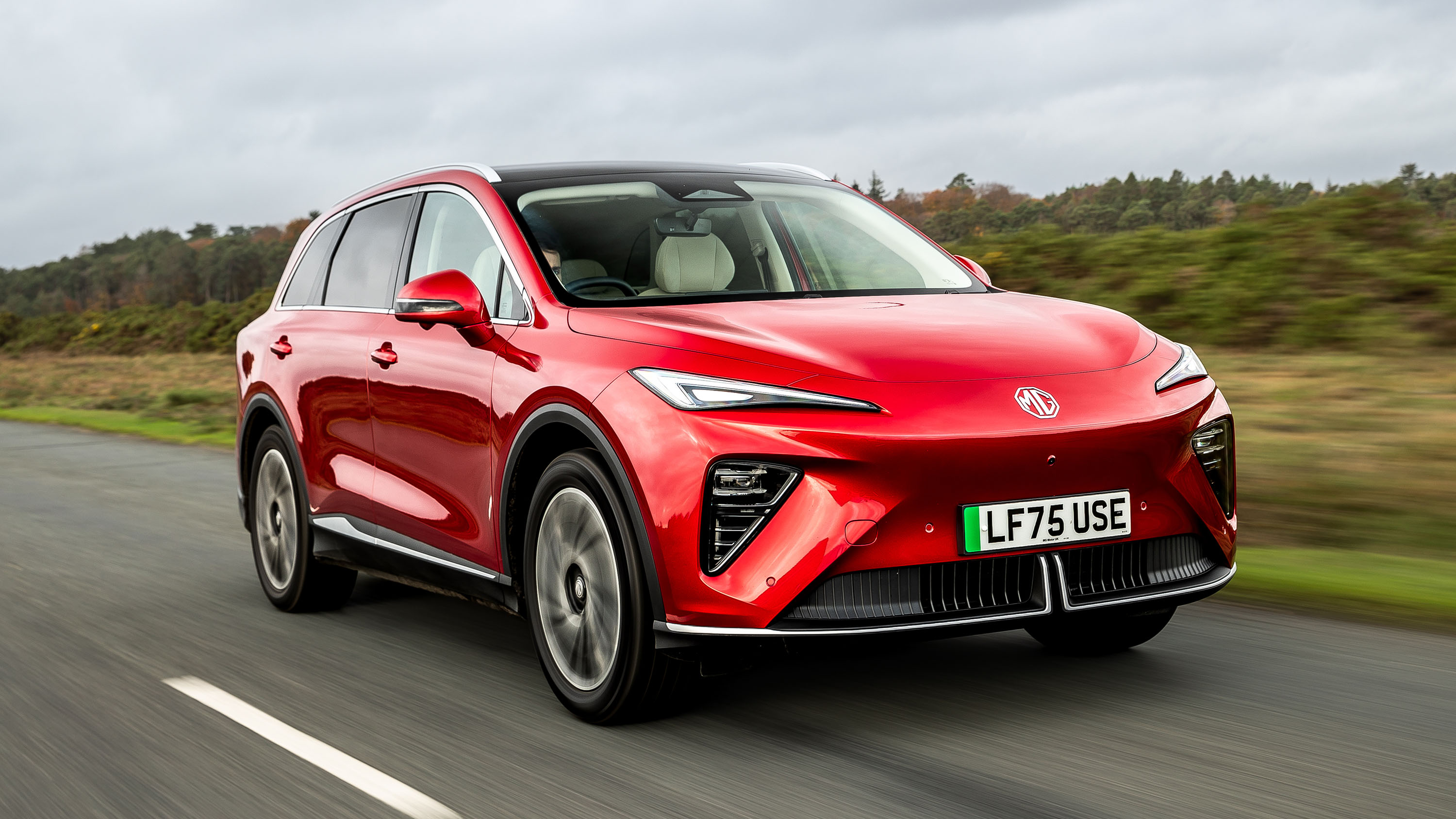 Vue extérieure du MG MGS6 EV, un SUV électrique gris foncé, garé dans une rue de ville moderne.