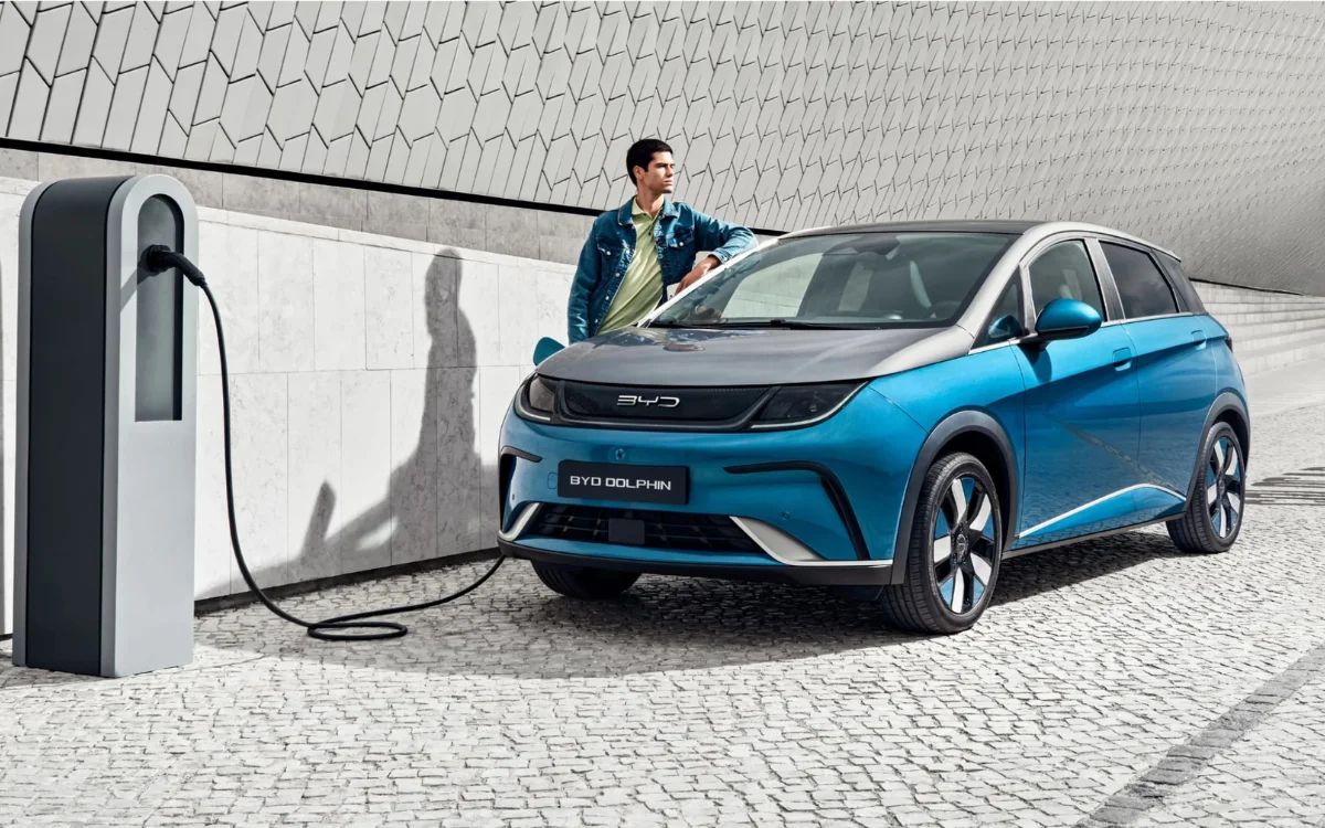 Une voiture électrique chinoise en train de charger à une borne de recharge moderne dans une ville européenne.