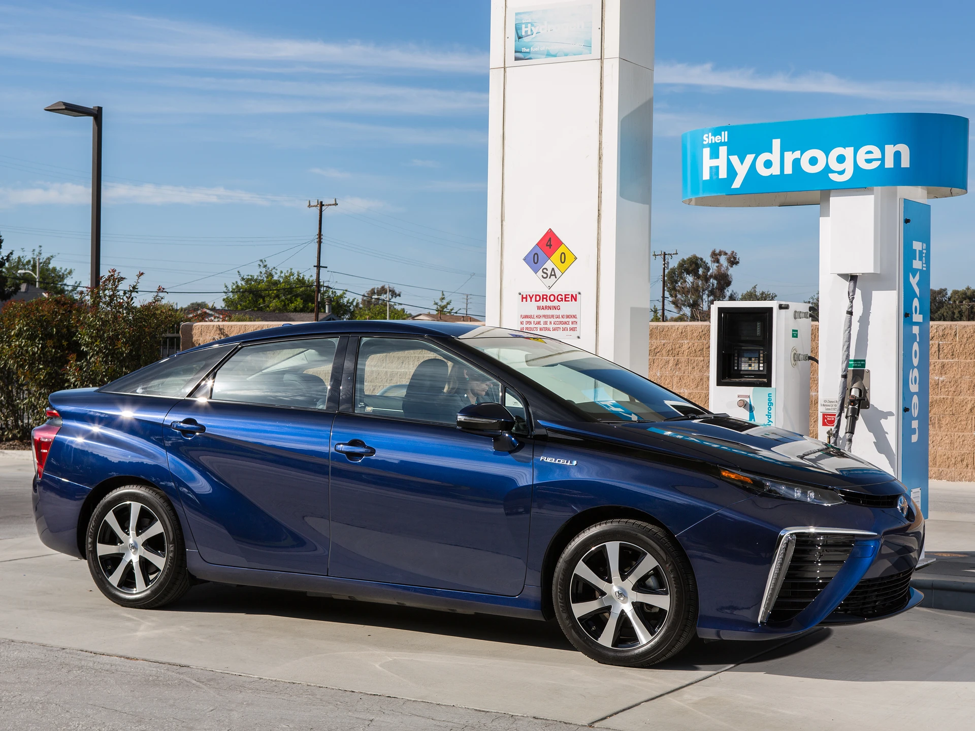 Une Toyota Mirai futuriste garée à une station de ravitaillement en hydrogène.