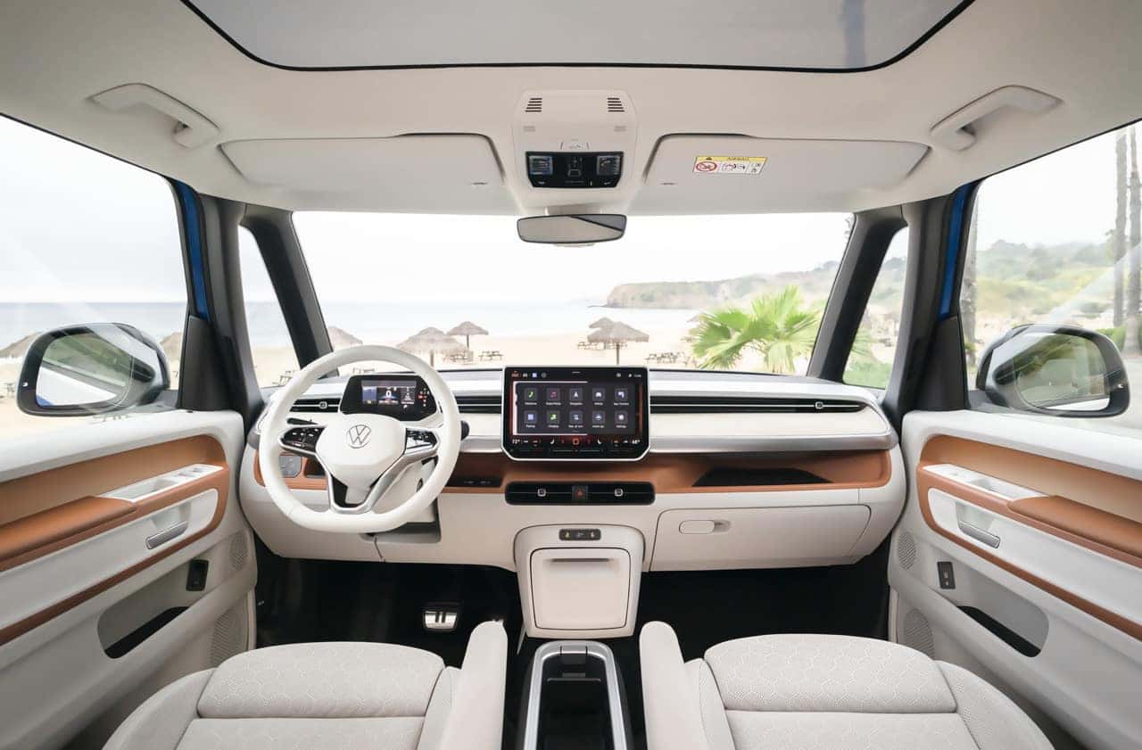 L'intérieur d'un Volkswagen ID.Buzz, avec des outils d'électricien rangés d'un côté et des sièges enfants de l'autre, illustrant sa polyvalence.