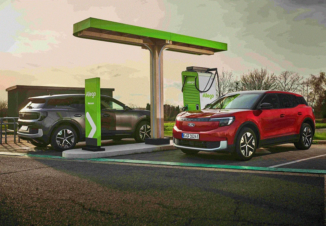 Un véhicule utilitaire électrique Ford blanc en train de charger à une borne de recharge rapide dans un environnement urbain français.