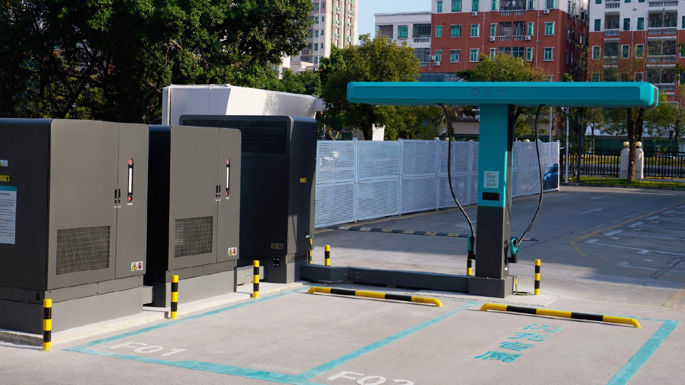 Une voiture électrique Denza Z9 GT se recharge à une borne BYD Flash Charging de 1 500 kW. La borne est imposante et les câbles sont robustes, suggérant une recharge ultra-rapide.