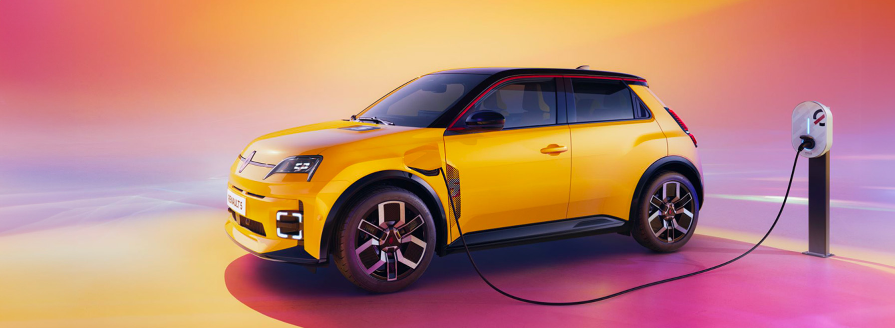 Une Renault 5 E-Tech électrique jaune en charge à une borne moderne.
