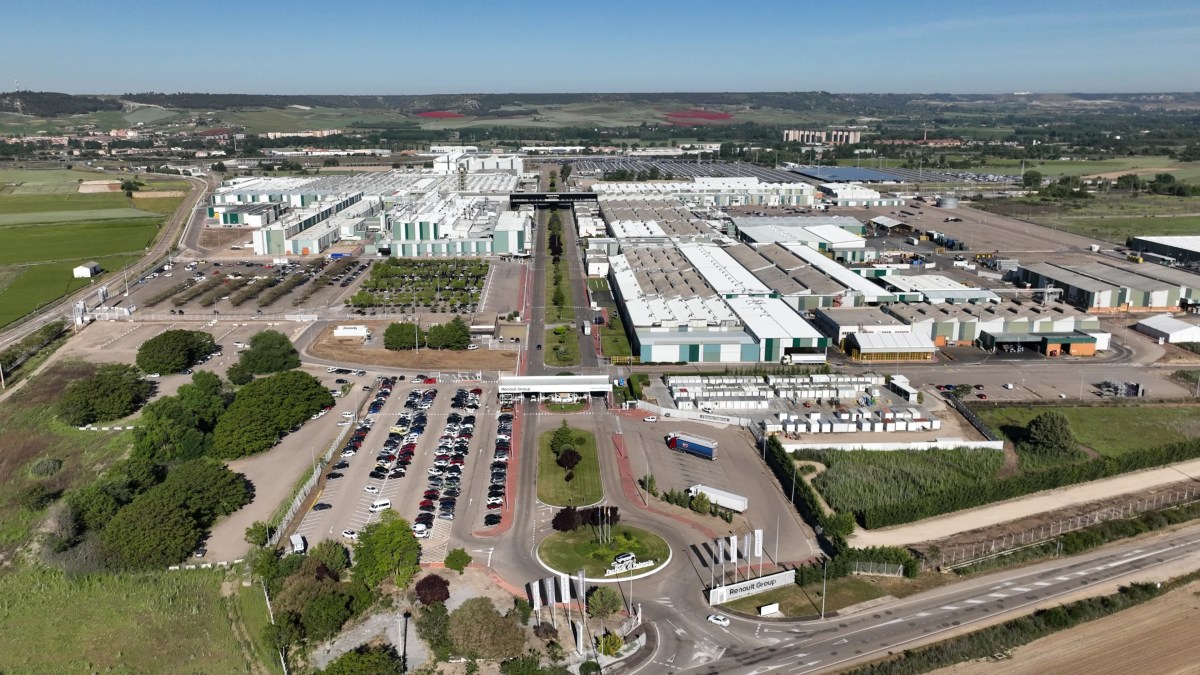 Vue intérieure d'une usine automobile moderne et lumineuse, montrant des robots assemblant des voitures électriques sur une chaîne de production.