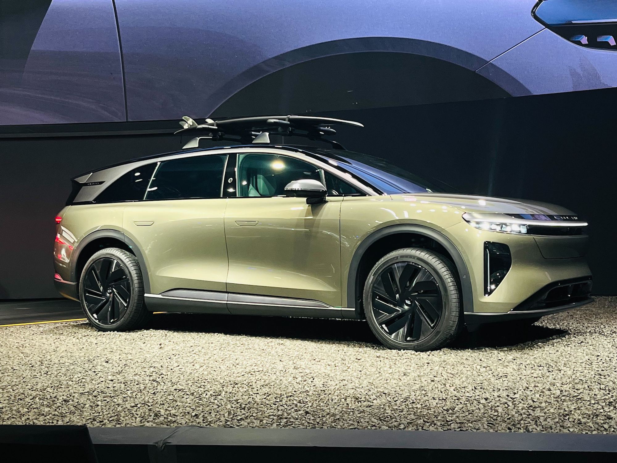 Le SUV électrique Lucid Gravity de couleur foncée, garé dans un environnement urbain moderne.