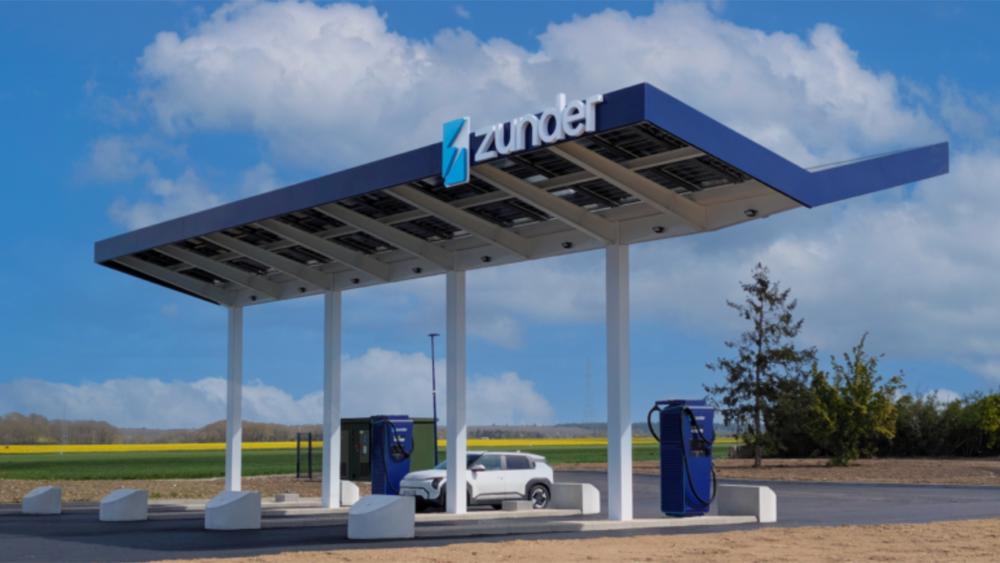 Vue d'ensemble de la station de recharge Zunder à Nonancourt, montrant plusieurs véhicules électriques en charge, incluant des voitures et des camions.