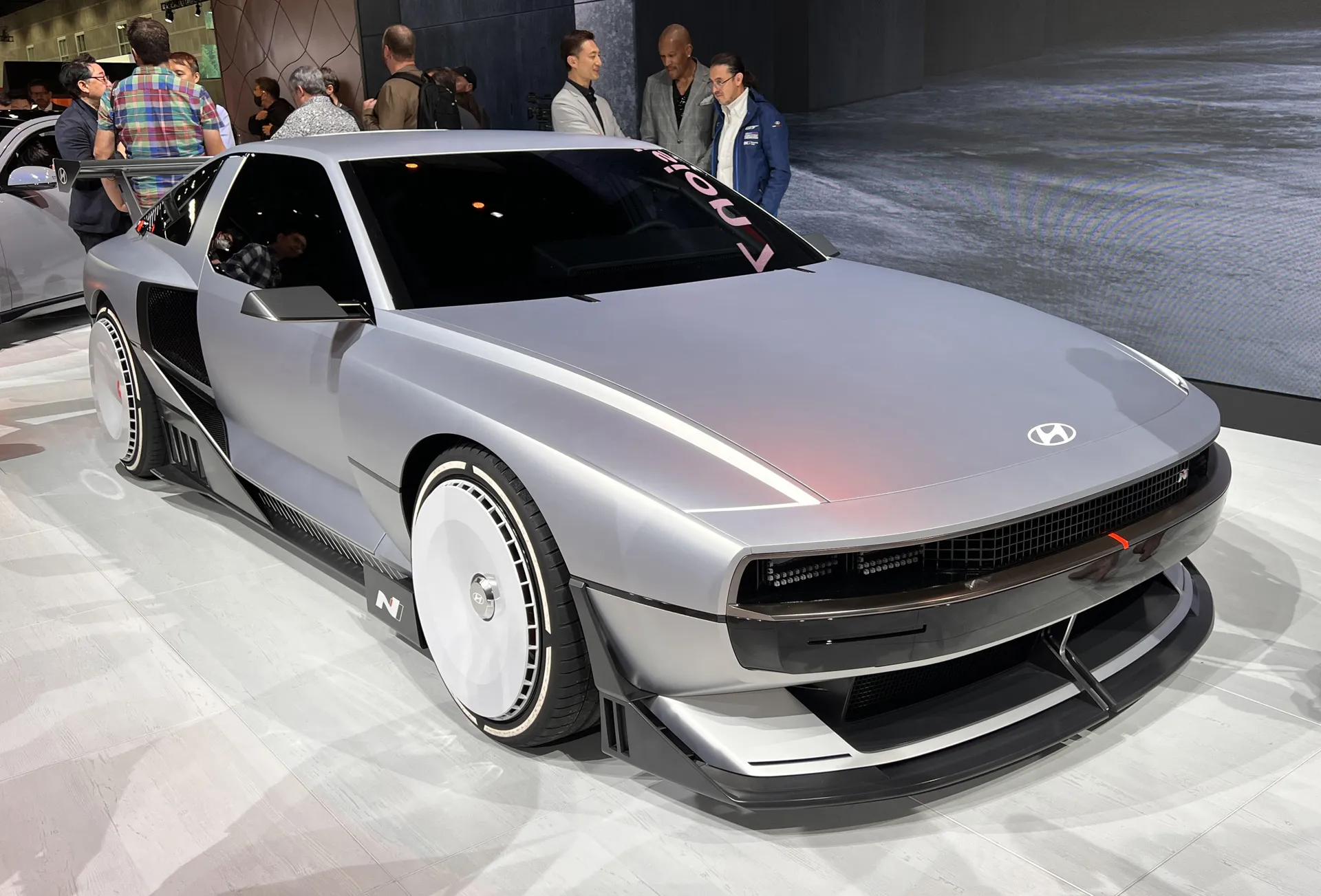 Vue plongeante et dynamique d'un concept de voiture de sport électrique Hyundai N sur une piste de course sinueuse.