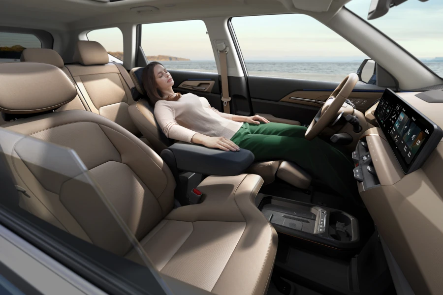 Intérieur du Kia EV5 2026, montrant les sièges confortables et l'éclairage d'ambiance créant une atmosphère relaxante.