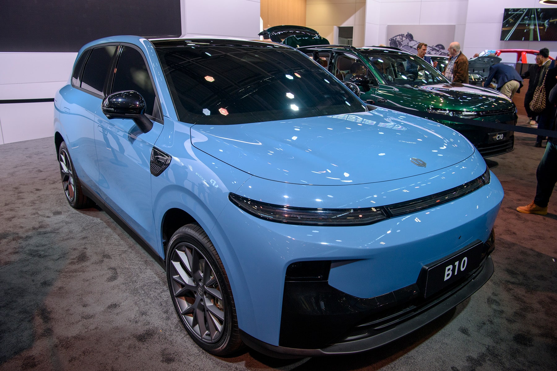 Leapmotor B10, un SUV électrique chinois, garé dans une rue de ville au crépuscule, avec ses phares et feux arrière allumés.