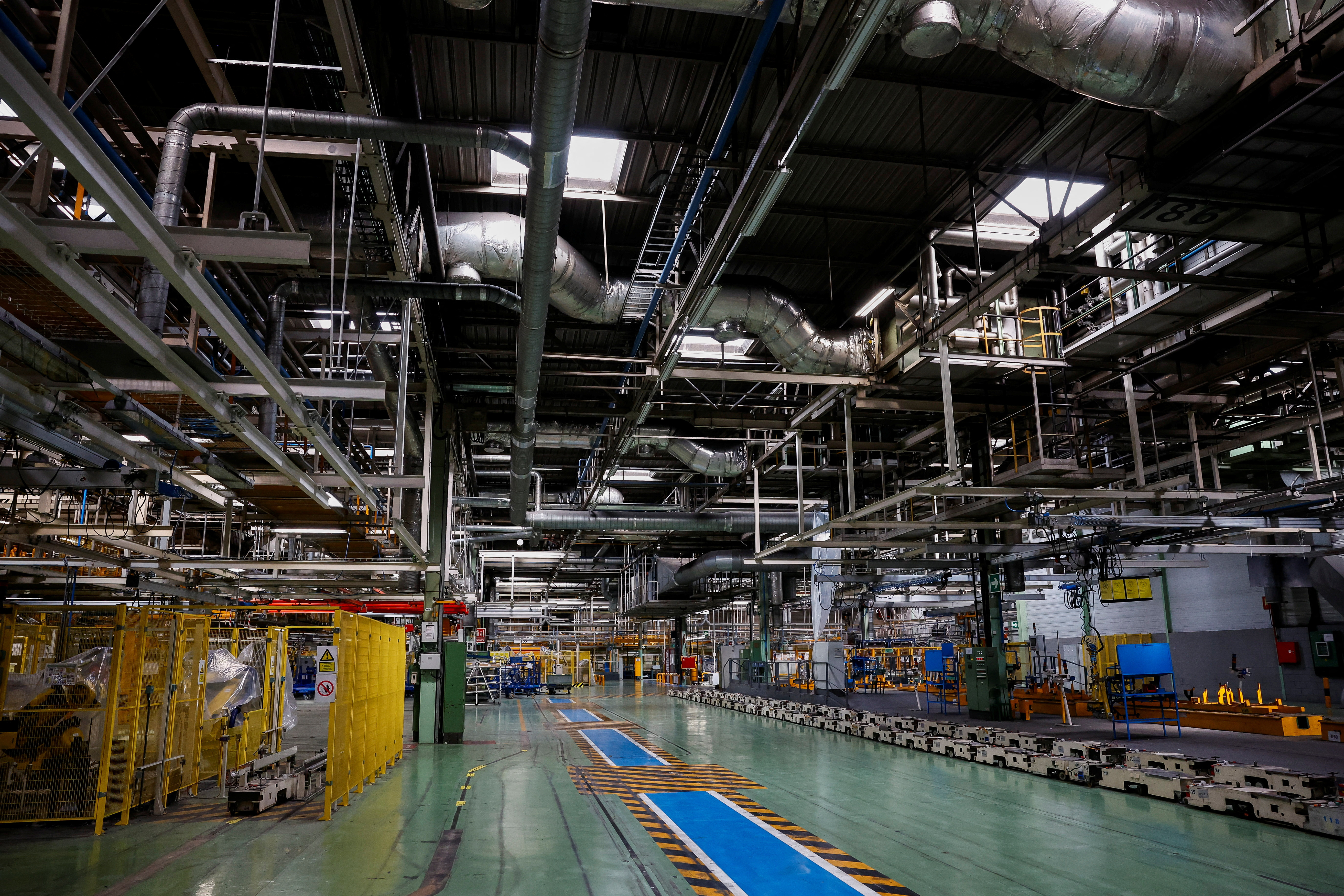 Vue d'ensemble d'une usine de fabrication automobile moderne et animée en Europe, avec des véhicules Chery sur la chaîne de montage.