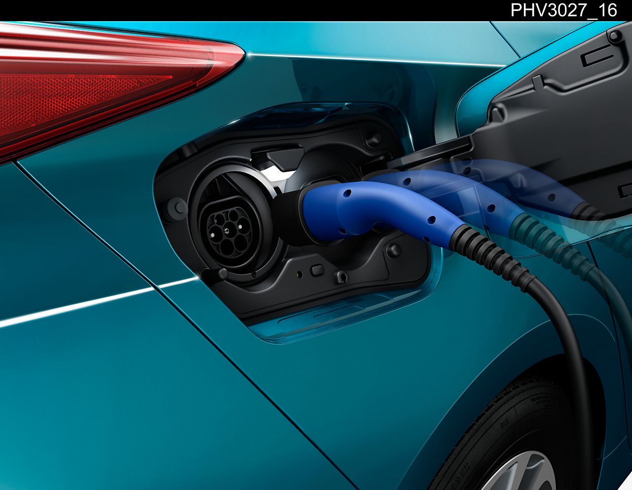 Une Toyota hybride rechargeable branchée à une borne de recharge domestique, garée dans une allée moderne.