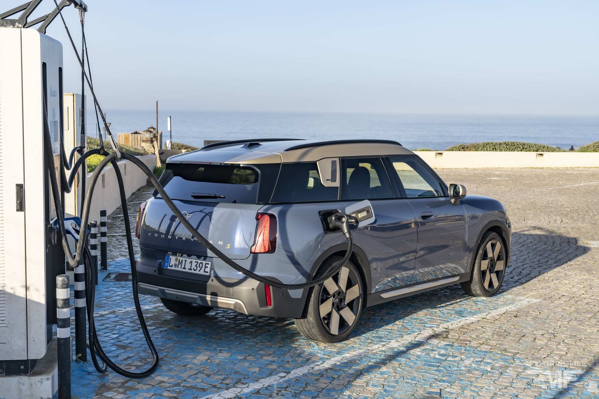 Mini Countryman E 2026 branché à une borne de recharge rapide dans un environnement urbain.