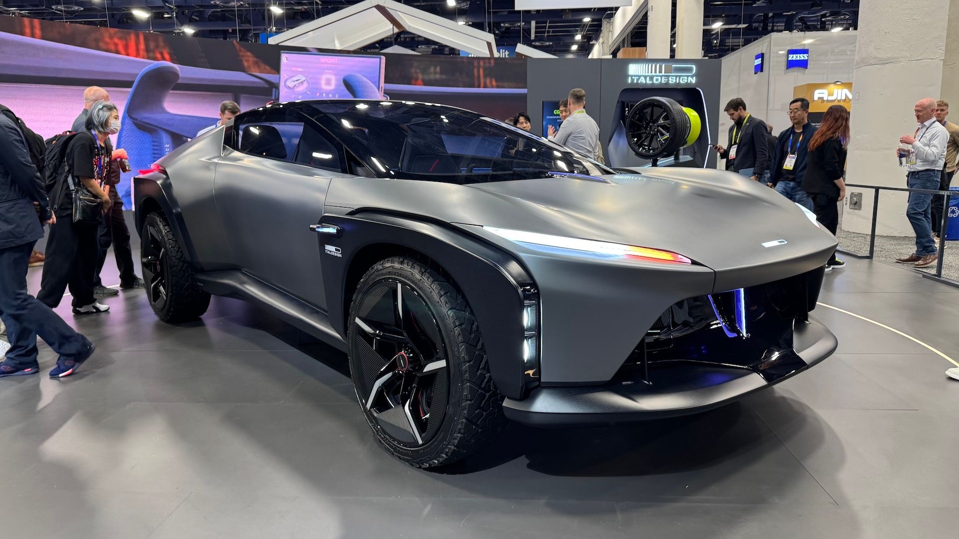 Vue latérale d'une supercar électrique sur une piste, avec des roues au design innovant suggérant des moteurs-roues.