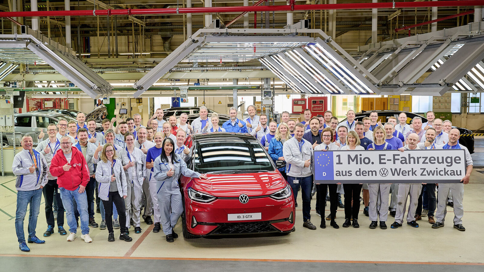 Vue intérieure de l'usine Volkswagen de Zwickau, montrant des robots et des ouvriers sur une ligne d'assemblage de voitures électriques.