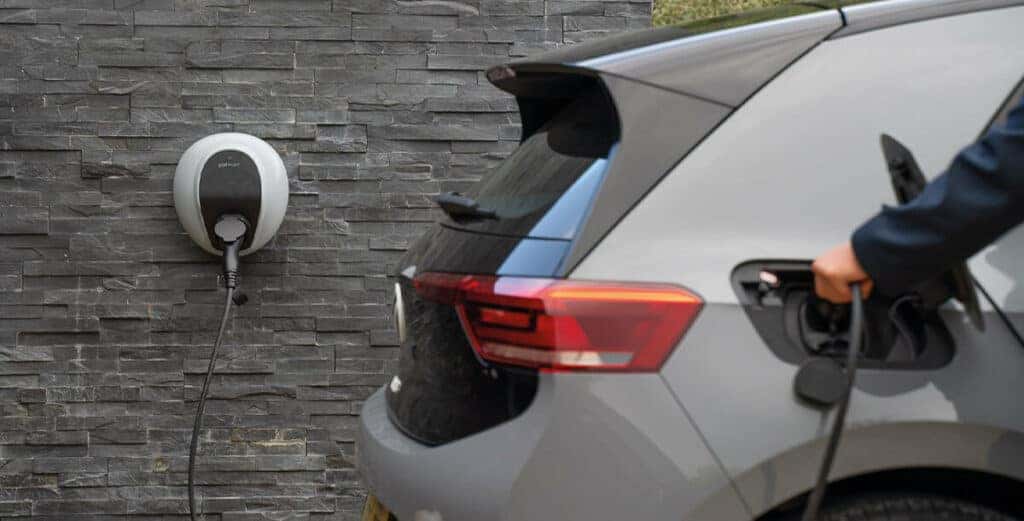 Deux voitures électriques Volkswagen, une ID.3 et une ID.4, en charge à une borne moderne.