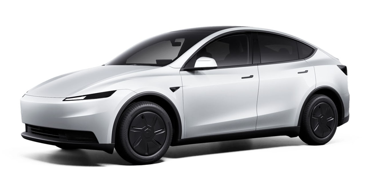 Une Tesla Model Y blanche roule sur une route européenne moderne, avec des bâtiments élégants en arrière-plan.