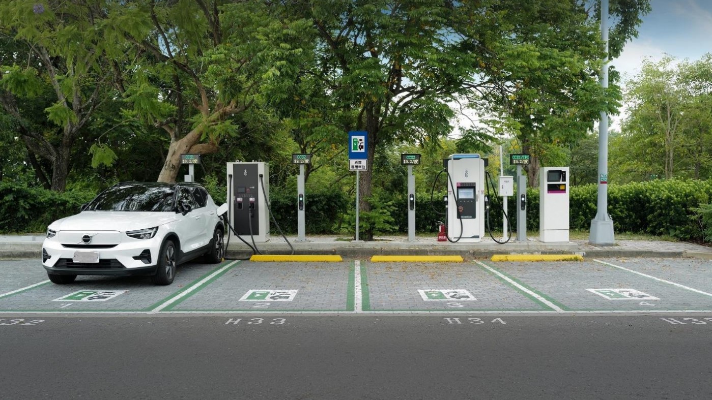Une station de recharge moderne pour véhicules électriques à Taïwan, avec plusieurs bornes et des voitures en charge, illustrant le développement des infrastructures.