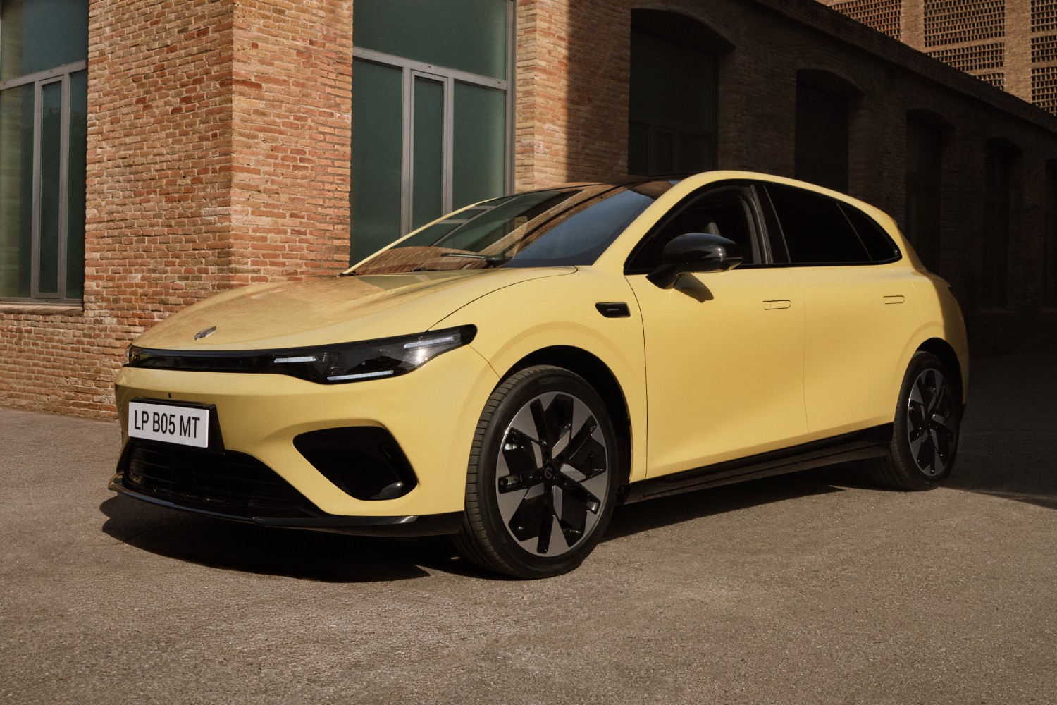 Vue extérieure d'une berline électrique Leapmotor B05 blanche, garée dans un environnement urbain, mettant en valeur son design moderne.