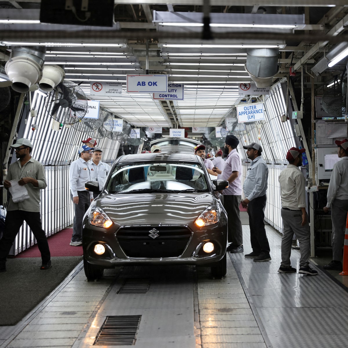 Une chaîne de production automobile de Maruti Suzuki avec des ouvriers et des robots assemblant des véhicules.