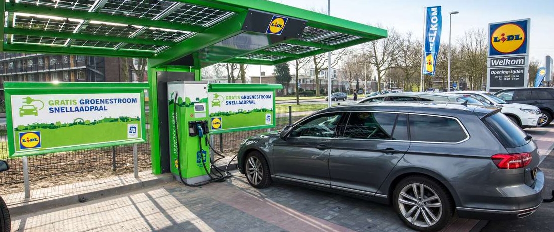 Des véhicules électriques en charge sur le parking d'un supermarché Lidl.