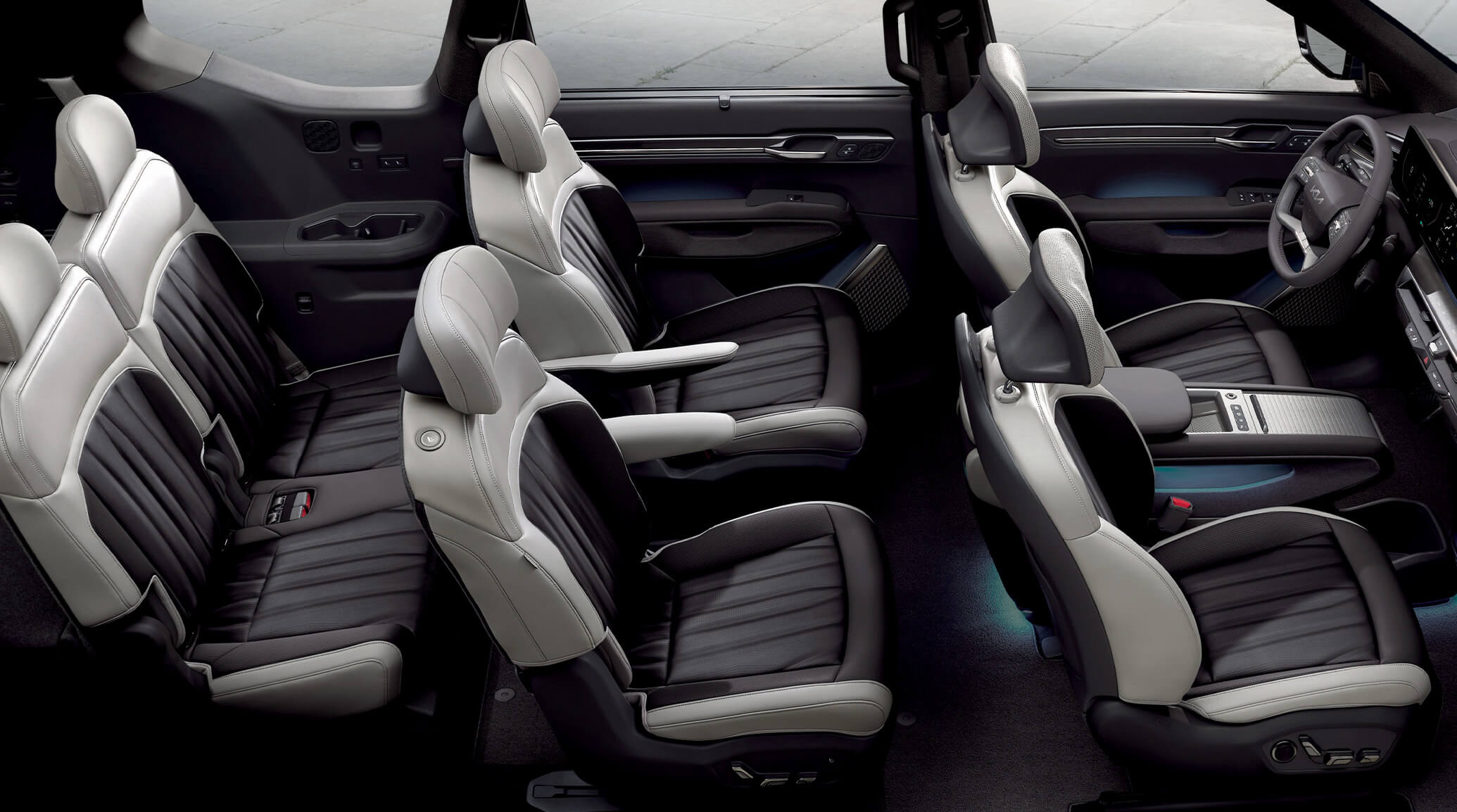 Intérieur d'un Kia EV9 avec ses sept sièges visibles, un grand écran incurvé sur le tableau de bord et des finitions intérieures haut de gamme.