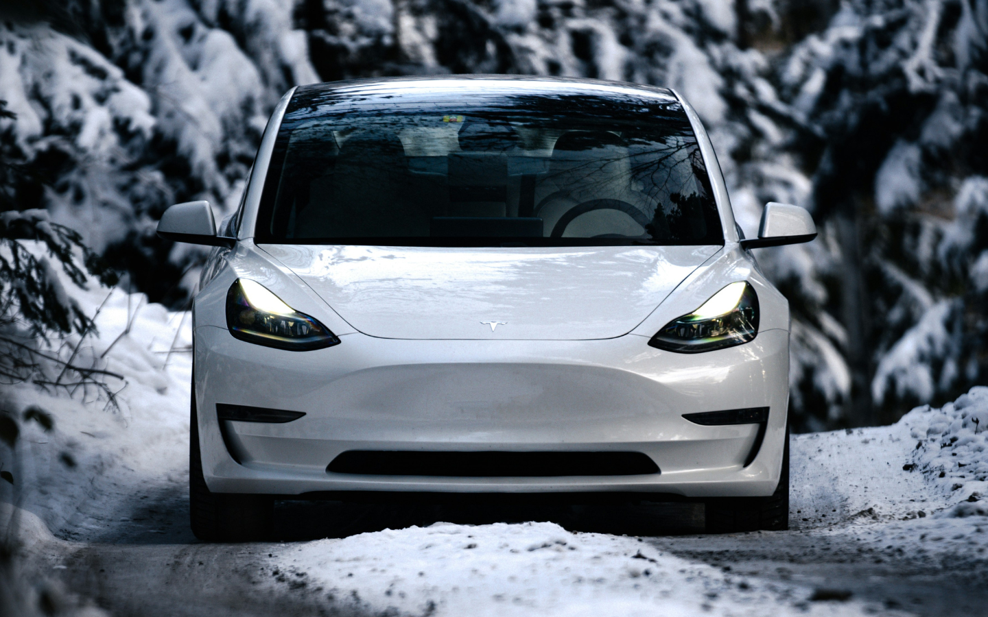 Un SUV électrique moderne roule sur une route enneigée en hiver, illustrant une conduite adaptée aux conditions froides.