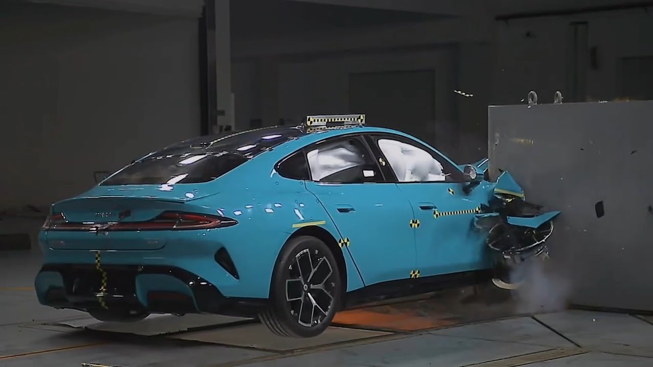 Une Xiaomi SU7 en plein crash test, avec des déformations contrôlées et les airbags déployés, illustrant les efforts de sécurité.