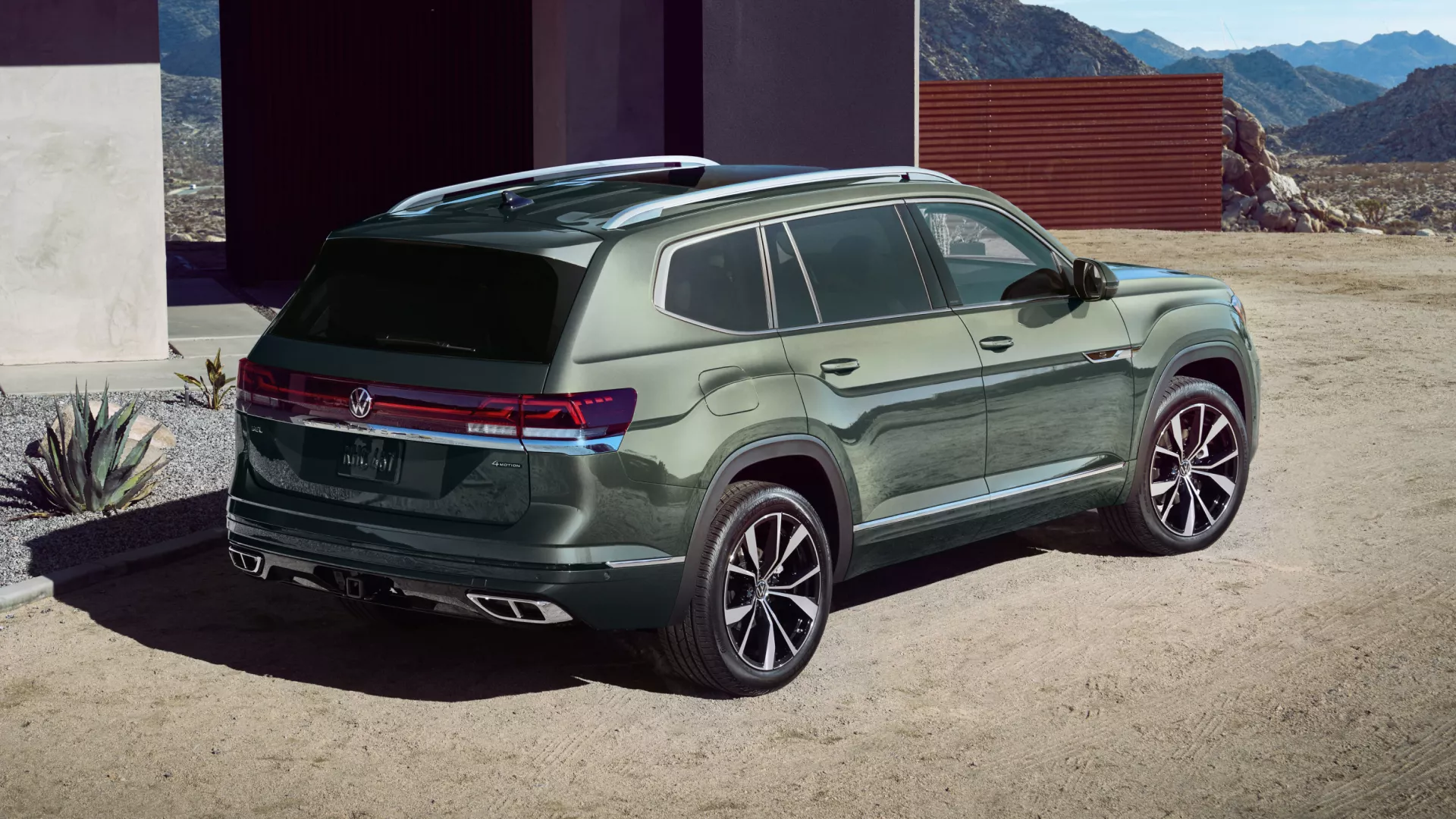 Un grand SUV Volkswagen Atlas gris foncé roulant sur une route de campagne américaine.