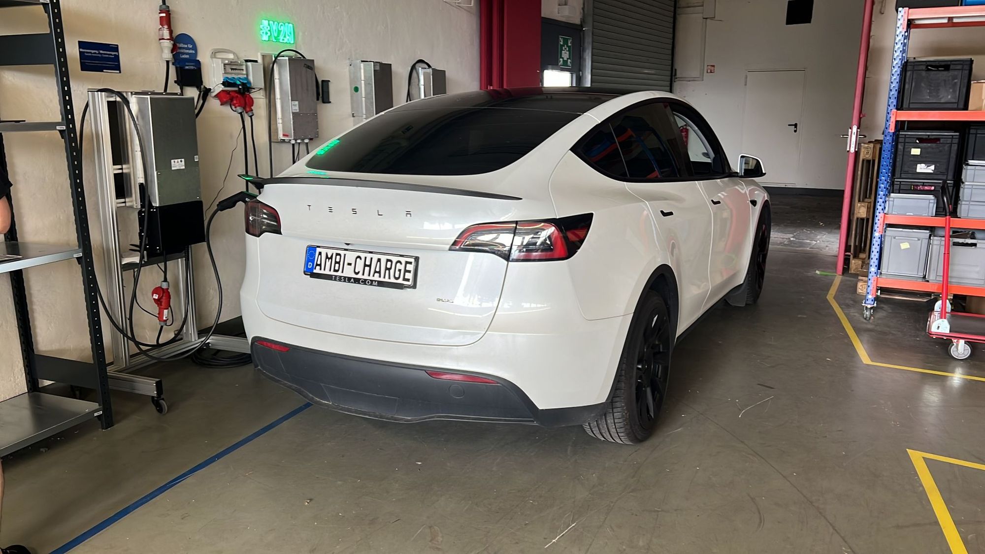 Gros plan sur le port de charge d'une Tesla Model Y, avec un câble de recharge bidirectionnel connecté, montrant la technologie V2H.