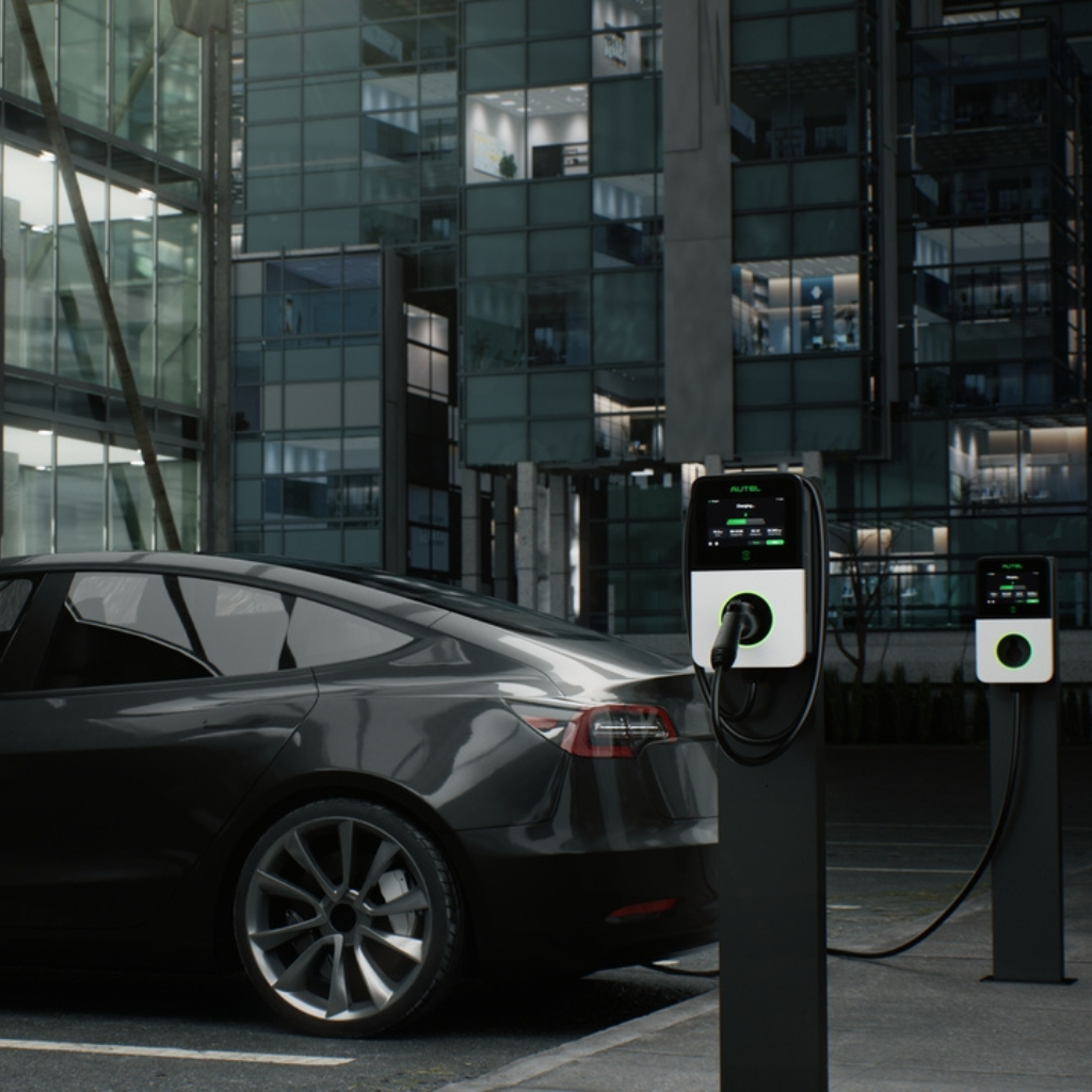 Plusieurs voitures électriques de différents modèles en charge à une station de recharge moderne en milieu urbain.