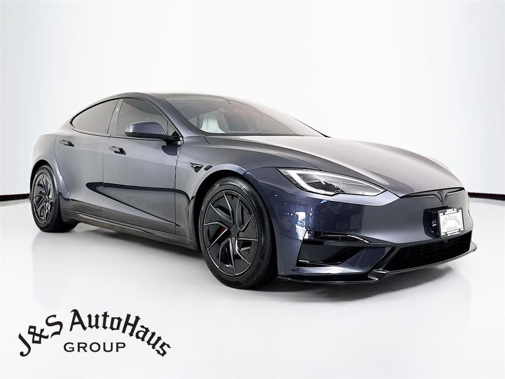 Une Tesla Model S Plaid d'occasion de 2026, de couleur sombre, garée dans un environnement urbain moderne, reflétant son design élégant et ses performances.